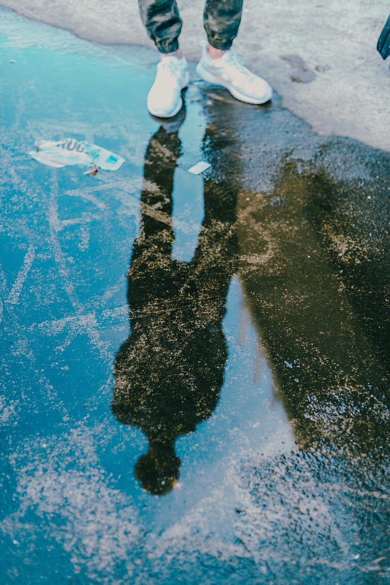 A person practicing self-affirmation in front of a mirror