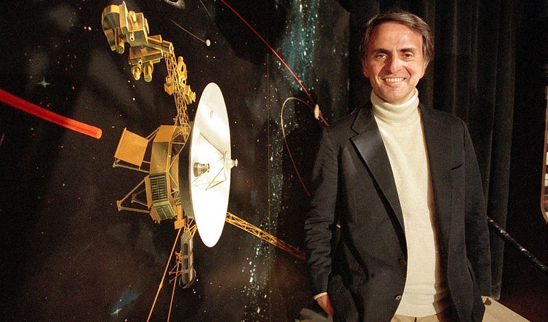 Carl Sagan with an illustration of the Voyager space probe